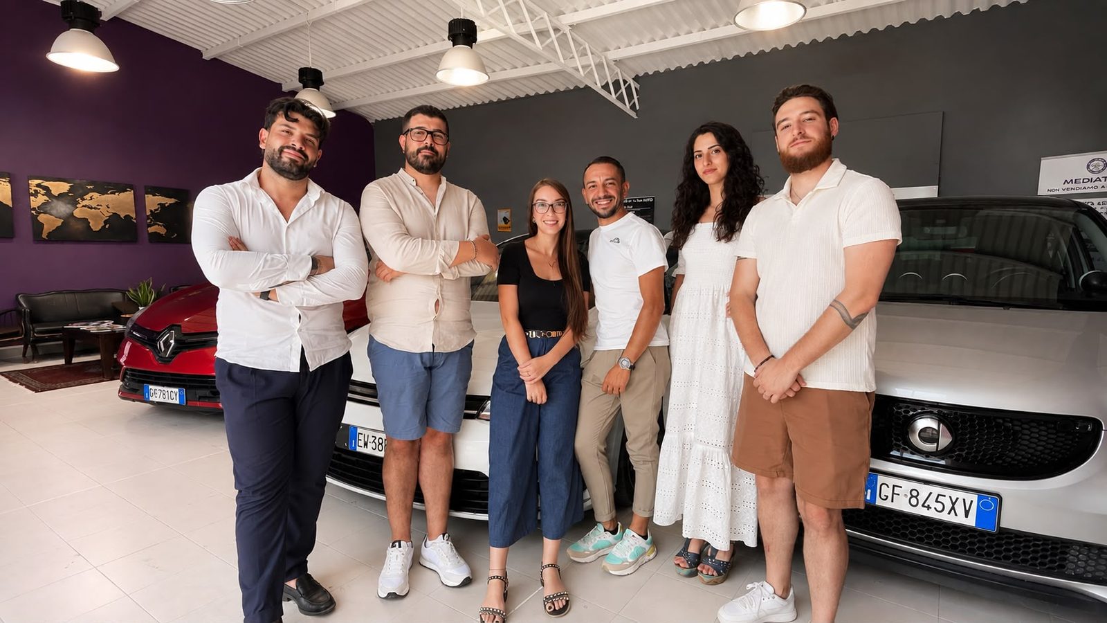 La squadra Mediaticar in agenzia, davanti alle auto in vetrina